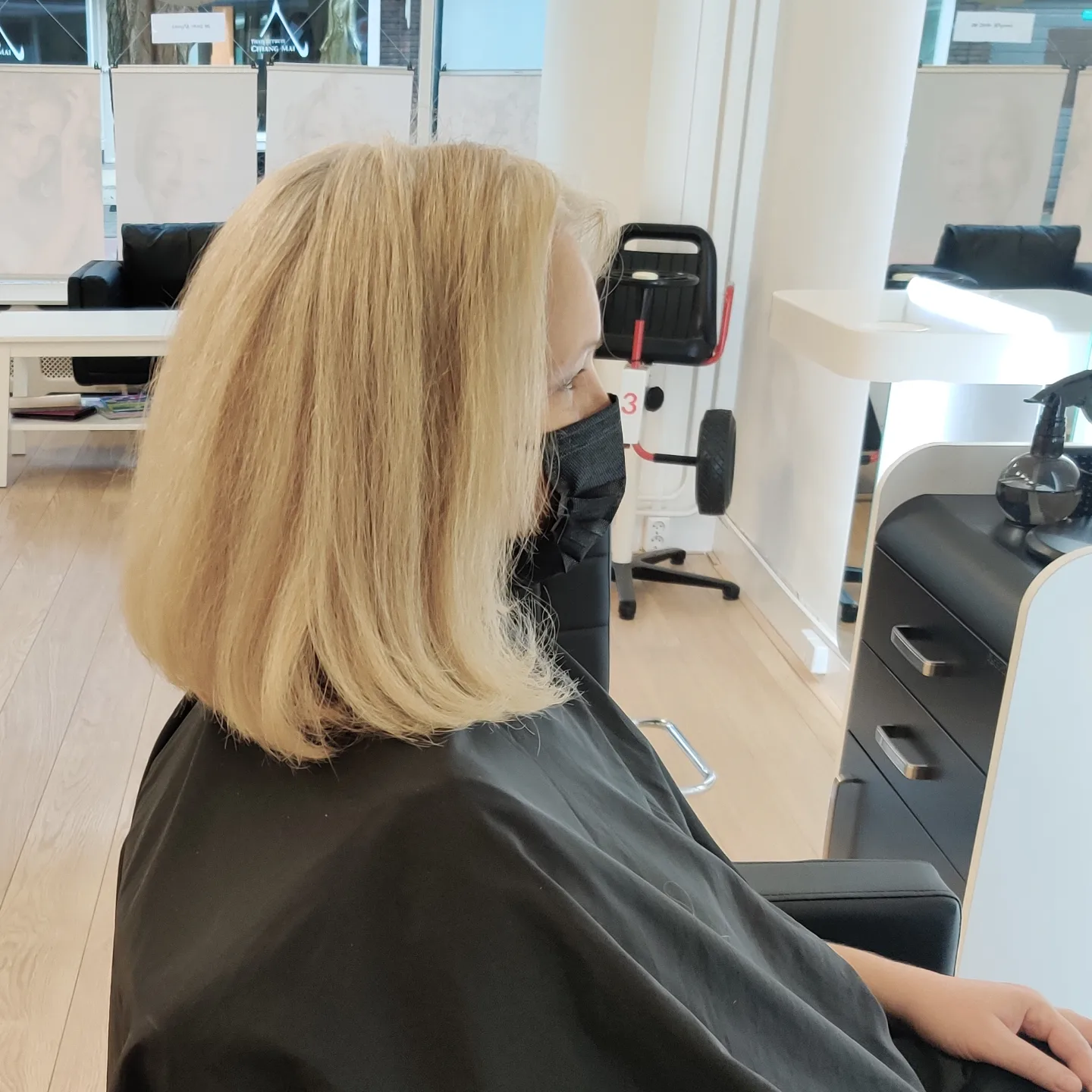 Blonde bob, klant in kapmantel in de salon